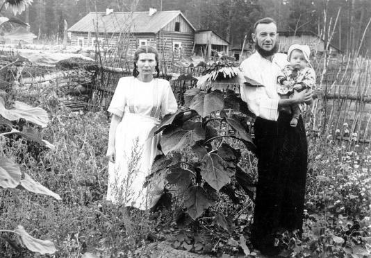 Jadwiga Pawlukowska z mężem i synkiem Ryszardem w przydomowym ogródku na przymusowej zsyłce w Maslejewie (Krasnojarski Kraj, ZSRR) po zwolnieniu z łagru