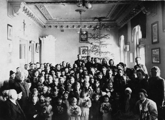 Uchodźcy polscy z 1939 roku w Domu Polskim w Ploesti podczas imprezy karnawałowej dla dzieci. W rękach dzieci trzymają prezenty gwiazdkowe rozdawane przez Dom Polski.