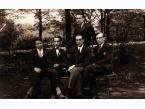 Grupa młodych mężczyzn na ławce w parku w Rydze (Łotwa), z prawej siedzi Wiktor Najmowicz, podpis na odwrocie: Towarzystwo pułkowe.