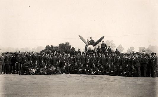 Personel Dywizjonu 303 przy samolocie Spitfire IX na lotnisku w Northolt (Wielka Brytania). Pod kołpakiem śmigła stoi odchodzący dowódca kpt. pilot Zygmunt Bieńkowski, na lewo od niego stoi nowy dowódca kpt. pilot Jan Falkowski.