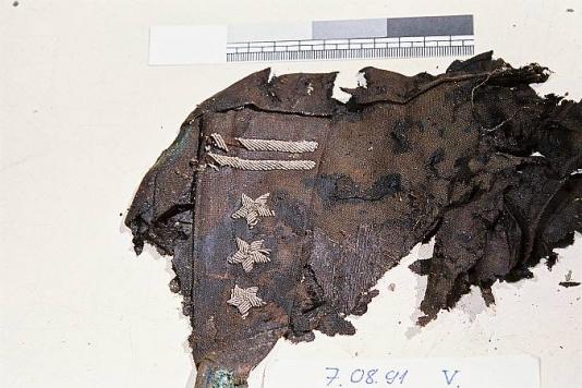 Fragment munduru (pagon ze stopniem pułkownika) odnaleziony podczas ekshumacji szczątków jeńców polskich ze Starobielska, ofiar zbrodni katyńskiej, zamordowanych przez NKWD na mocy decyzji z 5 marca 1940