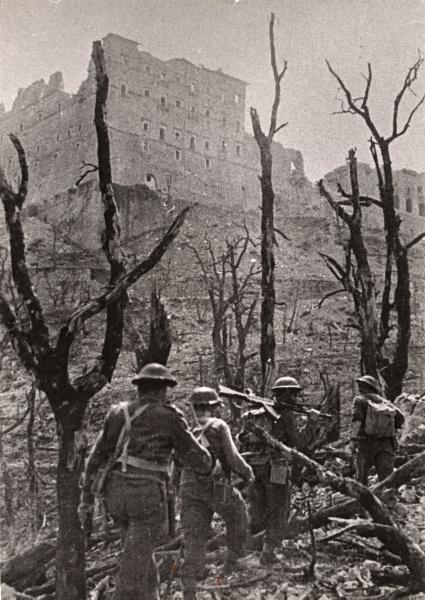 Żołnierze 2 Korpusu Polskiego w drodze do opactwa. W oddali ruiny klasztoru widziane poprzez okaleczone kikuty posiekanych pociskami drzew. Podpis na odwrocie: Patrol.