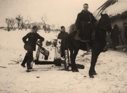Żołnierze Wehrmachtu stoją przy niemieckiej armacie przeciwpancernej Pak 37, ubrany w kożuch żołnierz na koniu ma przy pasie kaburę do pistoletu P08. Fot. NN, udostępnił Stanisław Blichiewicz.
