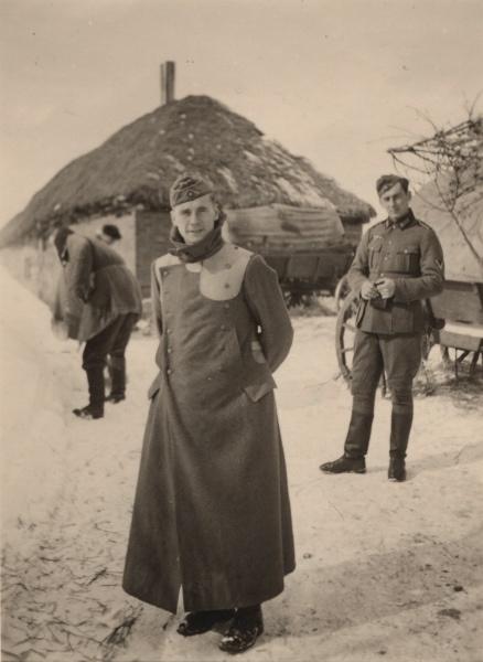 Żołnierze niemieccy na froncie wschodnim. Na pierwszym planie szeregowy Wehrmachtu  w płaszczu z doszytymi na ramionach wzmocnieniami wykonanymi ze skóry, na drugim planie kapral Wehrmachtu. 