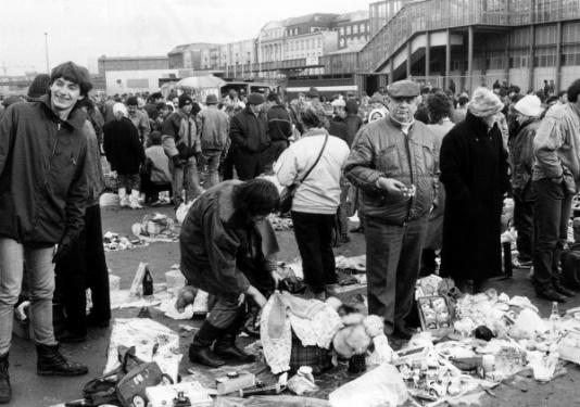Handel uliczny w Berlinie Zachodnim po upadku muru berlińskiego, na zdjęciu grupa handlarzy z Polski. 